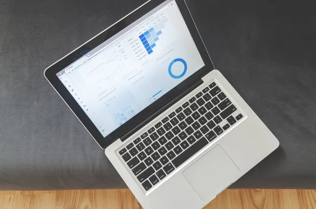Overhead view of a laptop showing data visualizations and charts on its screen. 5 licence units that quietly change SEO tools costs