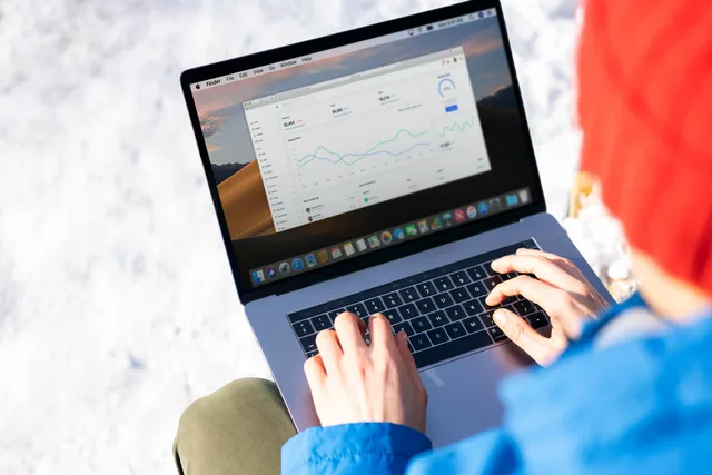 A person in a blue jacket analyzing business analytics on a laptop outdoors during winter. SEO tools measurement mistakes that weaken your evidence